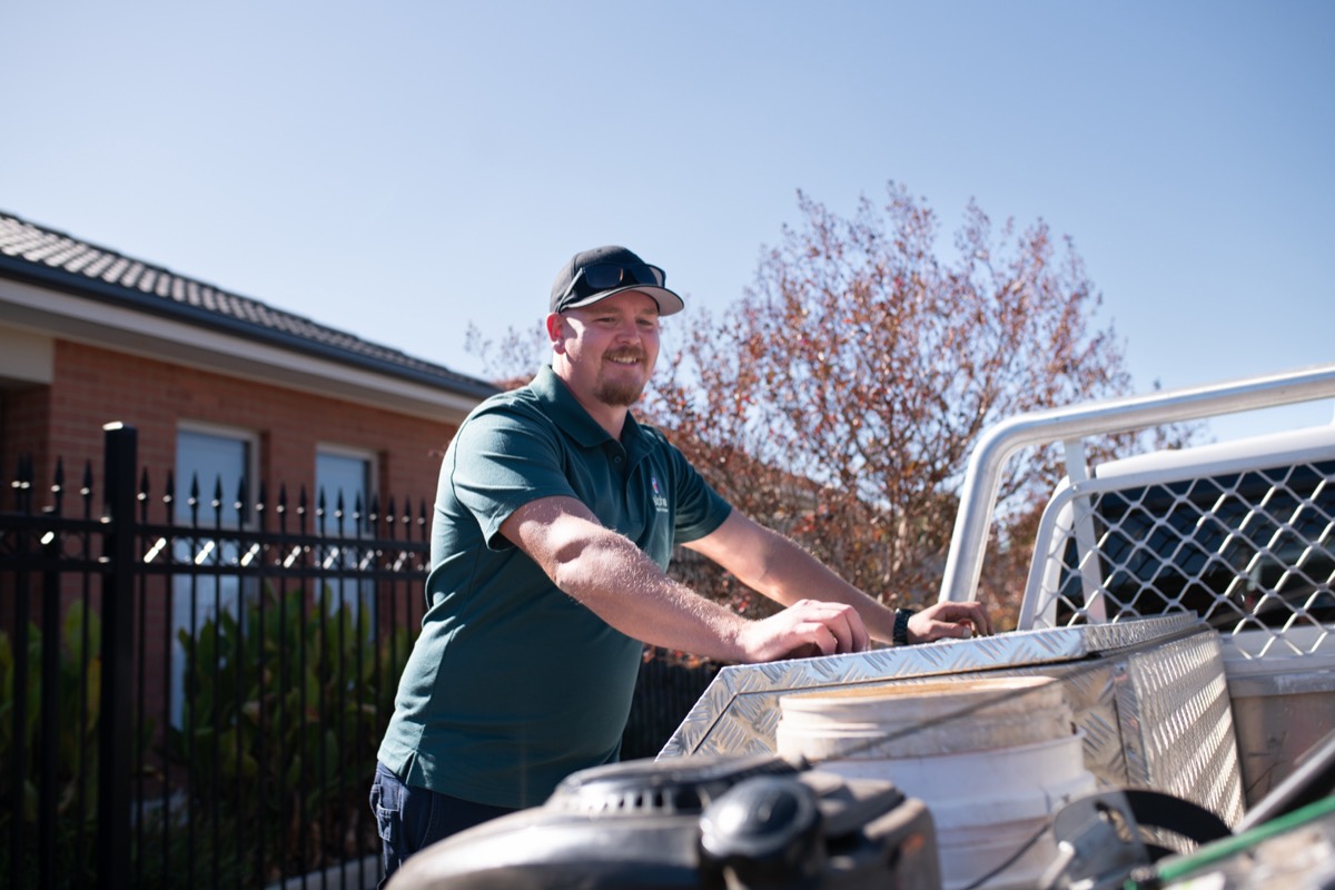 A home maintenance worker loading equipment into a work ute